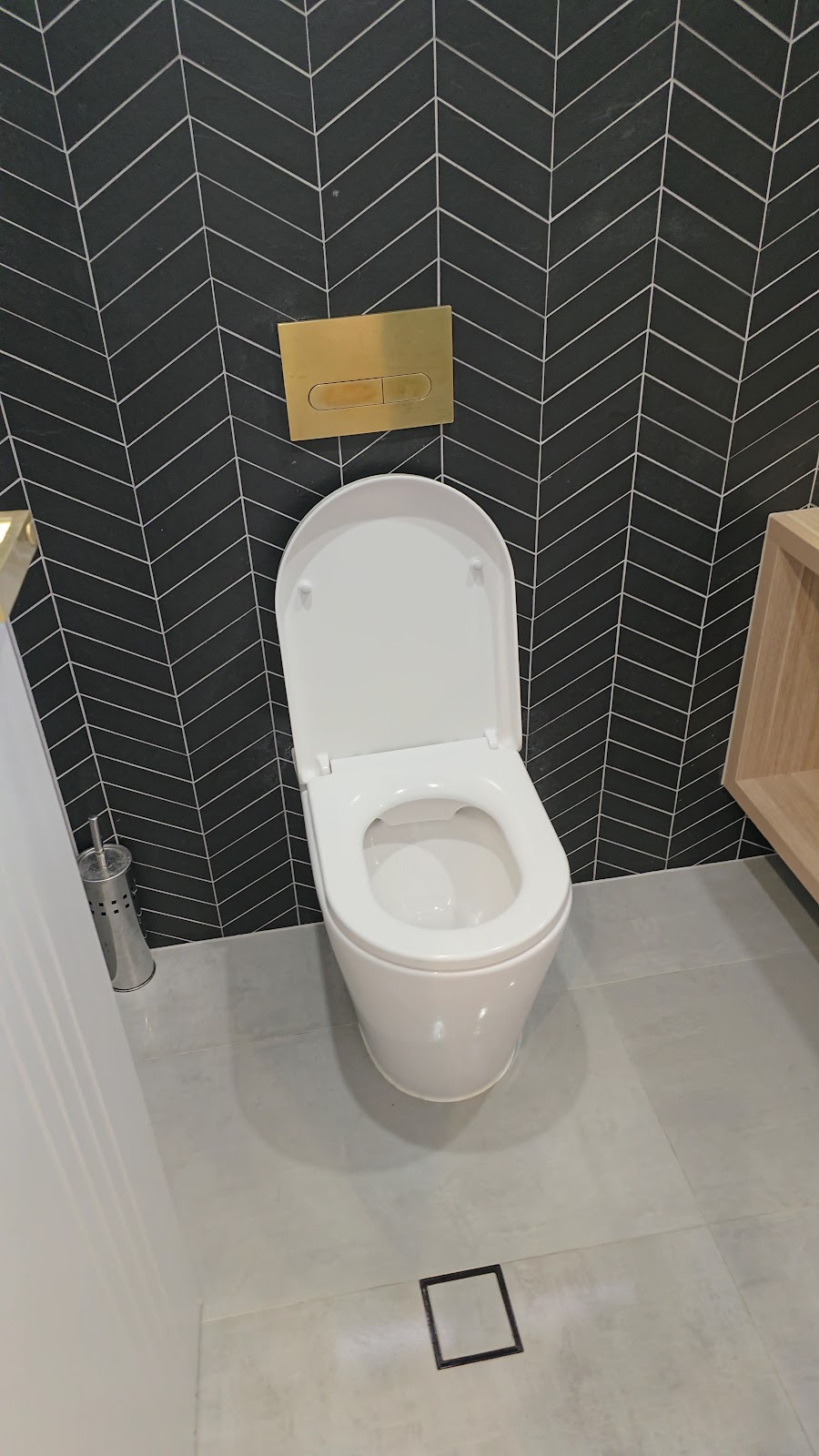 Toilet with chevron tile and gold fittings