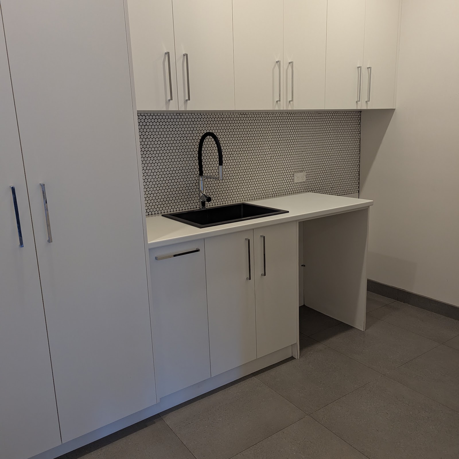 Kitchen sink with black tapware and penny tile